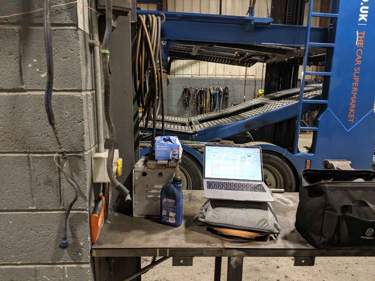 Laptop dashboard on a workbench beside a transporter